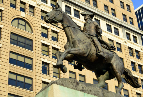 Statue of Caesar Rodney on horseback with state capitol building in background